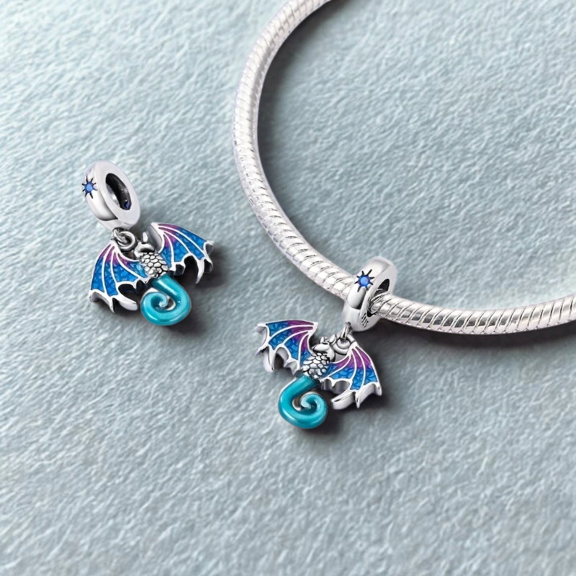 Charm dragon bleu et rose avec ailes ouvertes sur bracelet